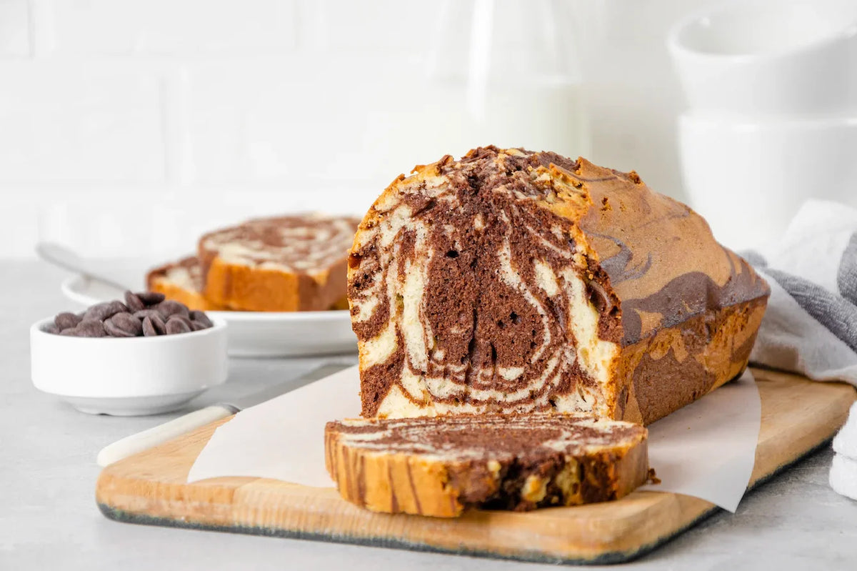 Cake marbré moelleux, tranché pour révéler ses spirales de pâte vanille et chocolat.